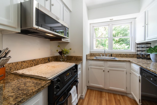 kitchen featuring black appliances, a sink, light wood-style floors, and white cabinets
