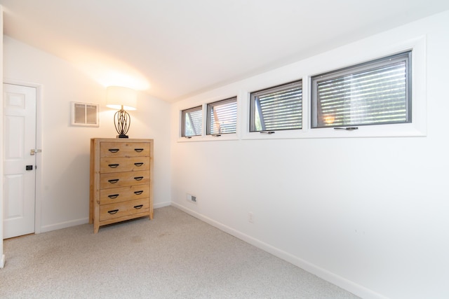 bedroom featuring baseboards, light colored carpet, and vaulted ceiling