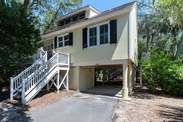 coastal home featuring a carport, stairway, and driveway