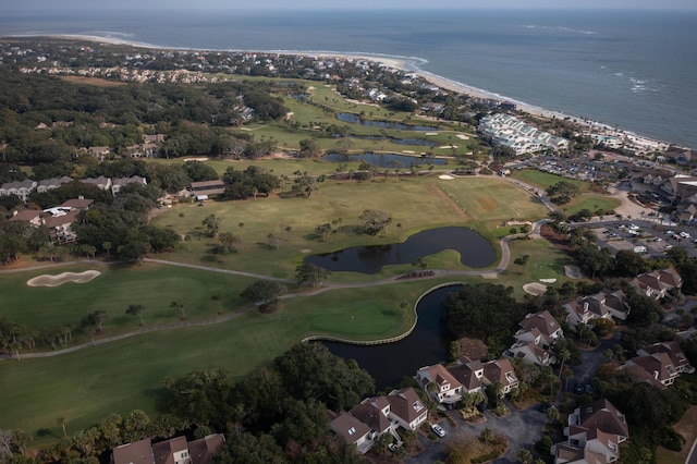 view of property location with a nearby body of water, nearby suburban area, and a golf course