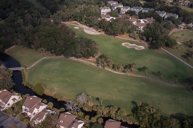 aerial view of property and surrounding area with a large body of water, a golf course, and nearby suburban area