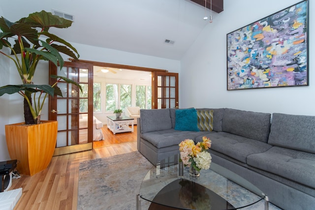 living room featuring lofted ceiling, wood finished floors, a ceiling fan, and french doors