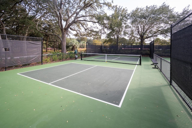 view of tennis court featuring fence