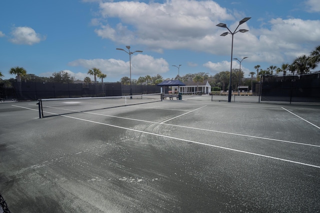 view of tennis court featuring fence