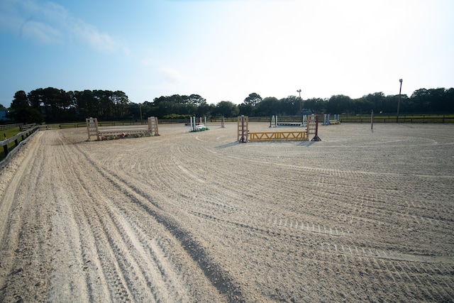 view of dirt / gravel road with an enclosed horse arena and a view of rural / pastoral area