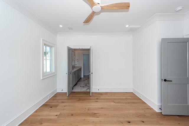 unfurnished bedroom featuring connected bathroom, light hardwood / wood-style floors, ceiling fan, and ornamental molding