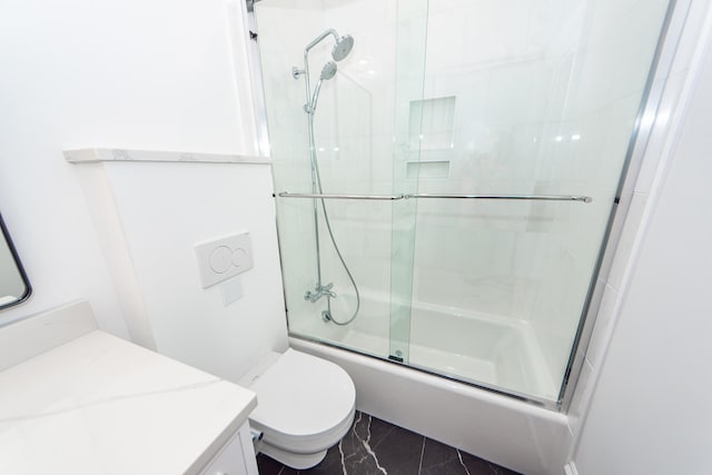 full bathroom featuring vanity, bath / shower combo with glass door, and toilet