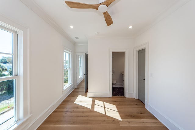 unfurnished bedroom with connected bathroom, ceiling fan, light hardwood / wood-style flooring, and crown molding