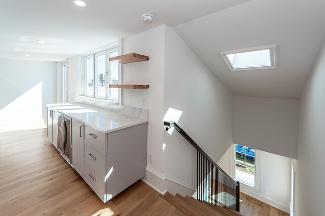 kitchen featuring plenty of natural light, white cabinets, and light hardwood / wood-style flooring