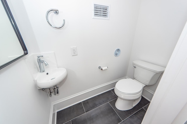 bathroom with tile patterned flooring, toilet, and sink