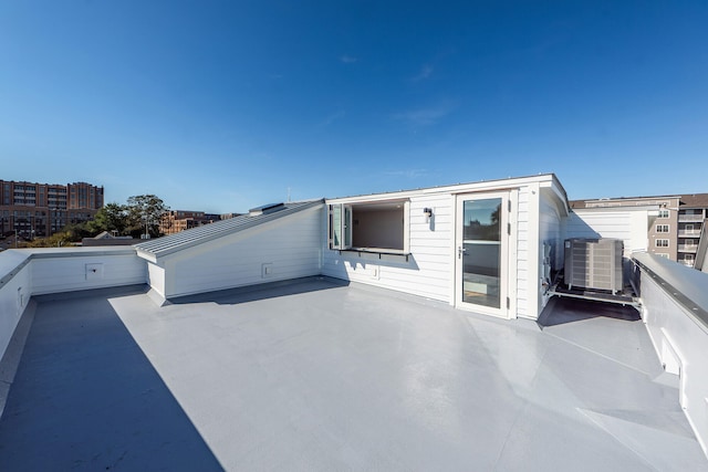 rear view of property featuring a balcony and central AC unit