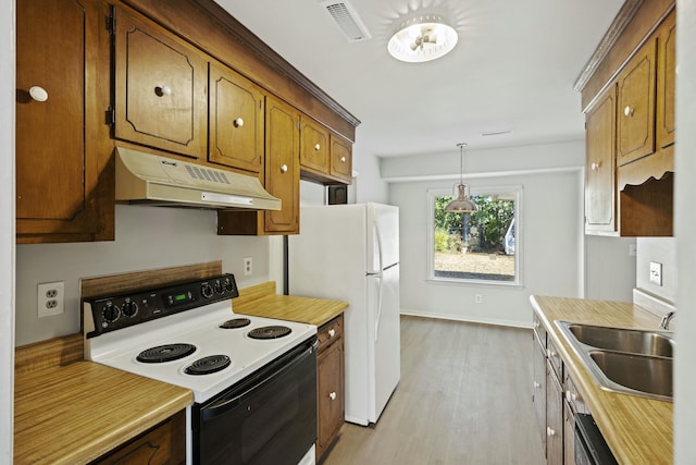 kitchen with pendant lighting, sink, white fridge, electric range, and light hardwood / wood-style floors