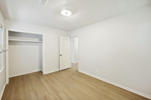 unfurnished bedroom with light hardwood / wood-style flooring and a closet