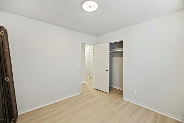 unfurnished bedroom with a closet and light hardwood / wood-style flooring