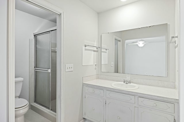 bathroom featuring ceiling fan, vanity, toilet, and an enclosed shower