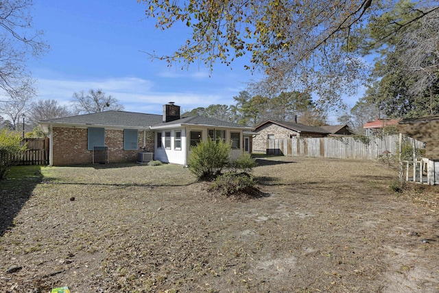 rear view of house with a yard and central AC