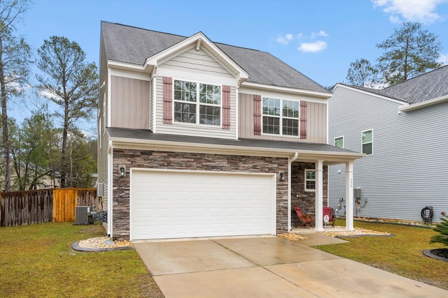 traditional-style house featuring a front lawn, fence, stone siding, and driveway