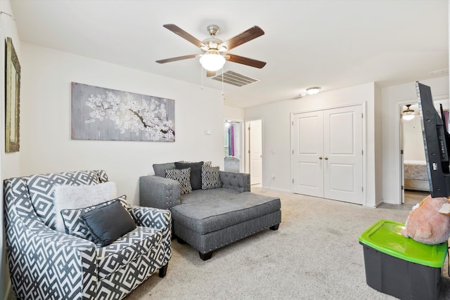 living room featuring visible vents, baseboards, carpet, and ceiling fan