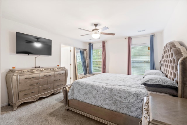 bedroom featuring a ceiling fan, visible vents, and light carpet