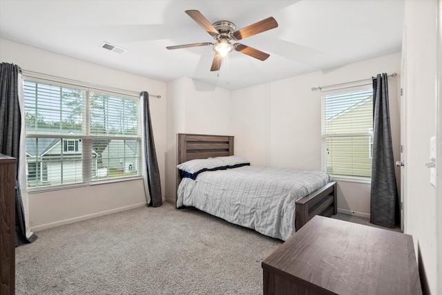 carpeted bedroom featuring visible vents, multiple windows, and baseboards