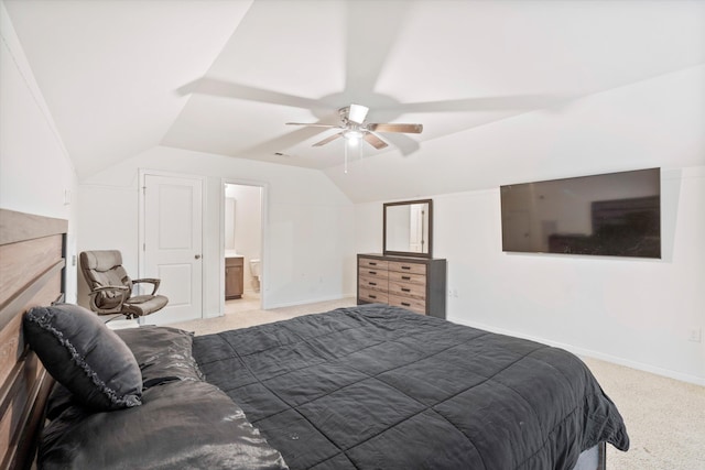 bedroom with ceiling fan, baseboards, vaulted ceiling, light carpet, and ensuite bathroom