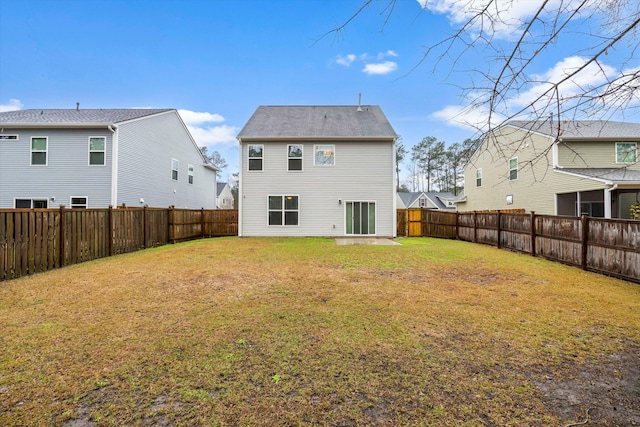 rear view of house featuring a yard and a fenced backyard