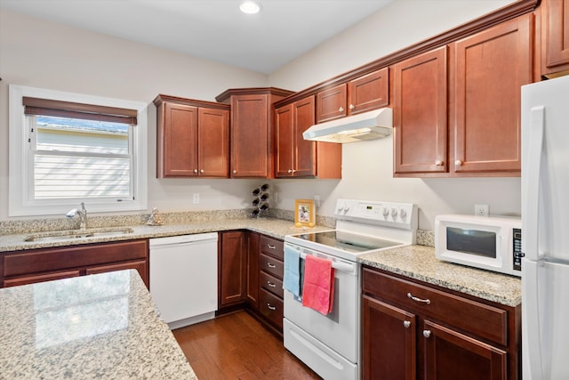 kitchen with dark wood-type flooring, a sink, light stone countertops, white appliances, and under cabinet range hood