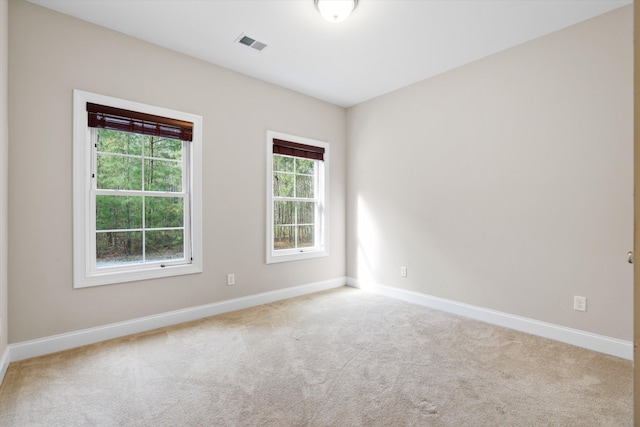 unfurnished room featuring carpet, visible vents, and baseboards