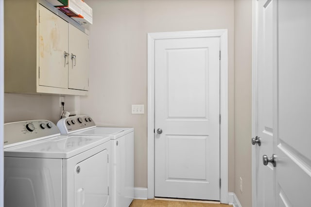 washroom featuring cabinet space, independent washer and dryer, and baseboards