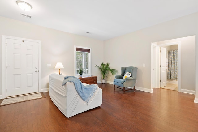 living room featuring baseboards, visible vents, and wood finished floors