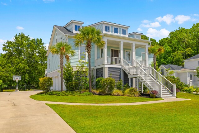 view of front of house with a garage, covered porch, and a front lawn