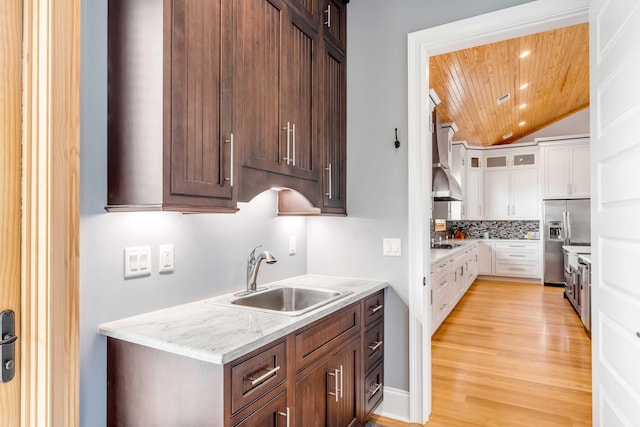 kitchen featuring white cabinetry, sink, light hardwood / wood-style flooring, stainless steel refrigerator with ice dispenser, and wood ceiling