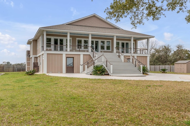 back of house featuring covered porch and a lawn