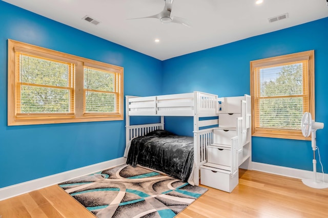 bedroom with ceiling fan, light wood-type flooring, and multiple windows