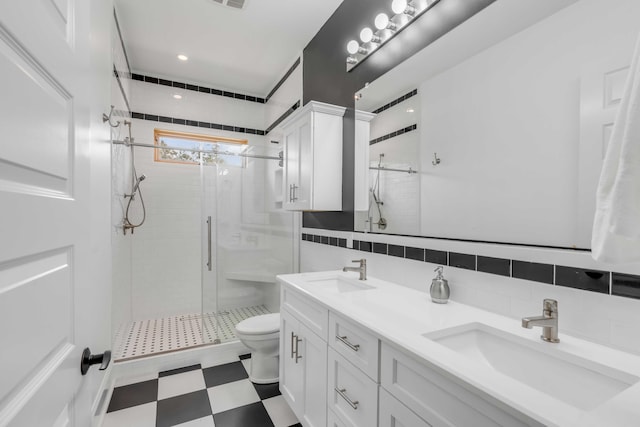 bathroom featuring backsplash, an enclosed shower, toilet, vanity, and tile walls