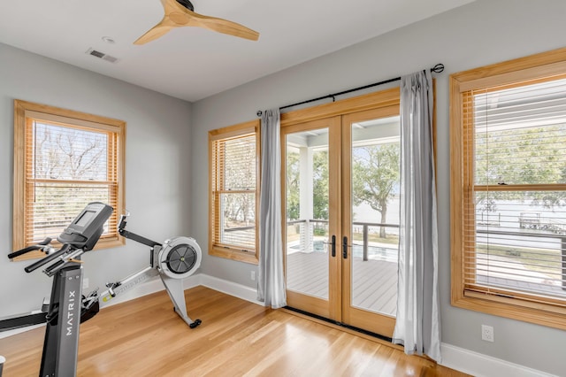 exercise area with a wealth of natural light, french doors, and light hardwood / wood-style floors