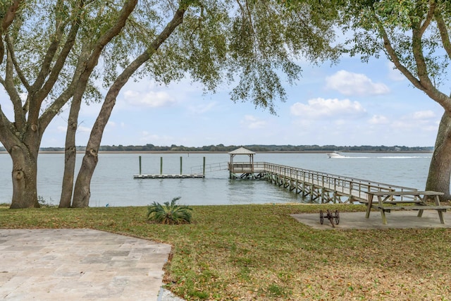 dock area with a lawn and a water view