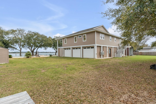 view of property exterior featuring a lawn, a water view, and a garage