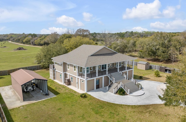 back of house with a carport, a storage unit, and a yard