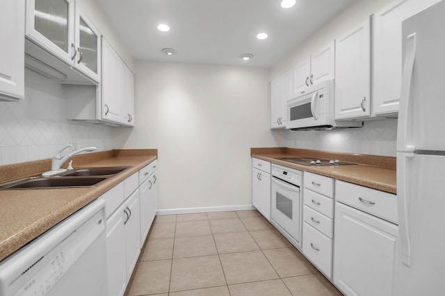 kitchen with light tile patterned flooring, white cabinets, white appliances, sink, and backsplash