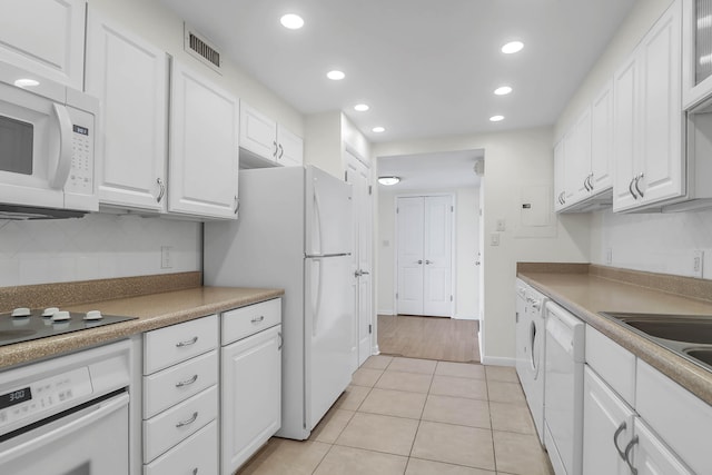 kitchen featuring light hardwood / wood-style floors, electric panel, white cabinets, and white appliances