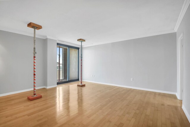 empty room featuring ornamental molding and hardwood / wood-style floors