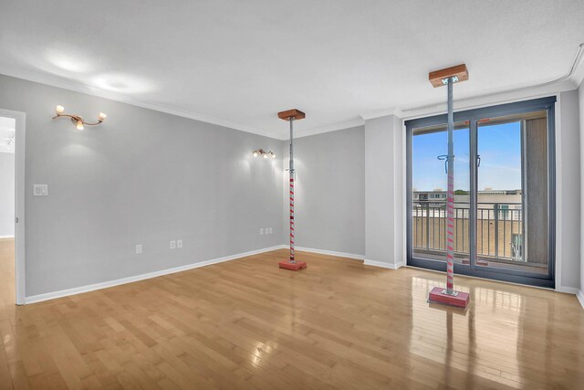 unfurnished room with plenty of natural light, wood-type flooring, and ornamental molding