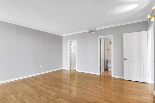 unfurnished bedroom featuring light hardwood / wood-style floors, ornamental molding, ensuite bath, and a closet