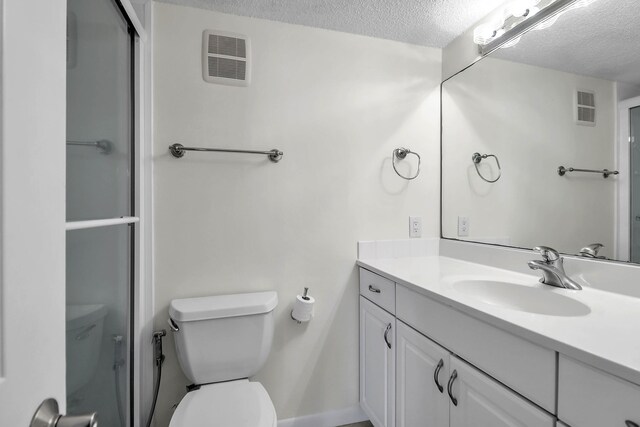 bathroom with toilet, vanity, and a textured ceiling