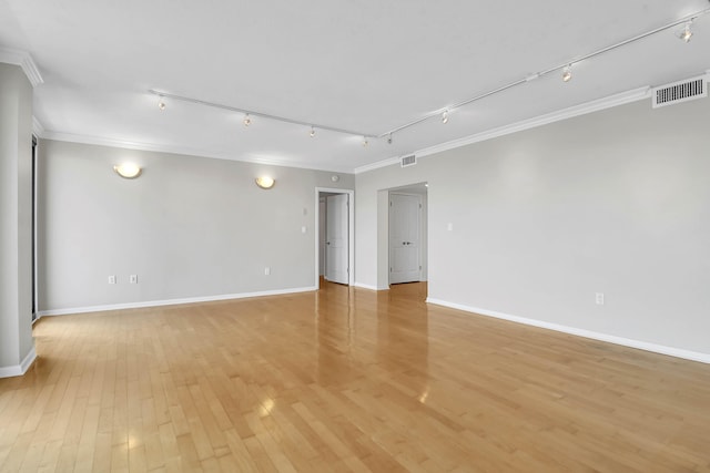 empty room featuring crown molding, light hardwood / wood-style flooring, and track lighting