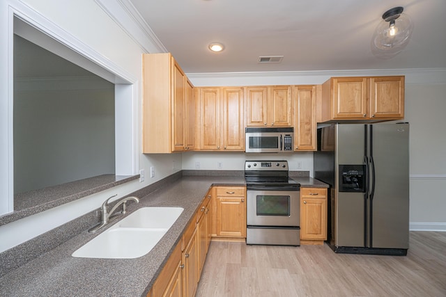 kitchen featuring appliances with stainless steel finishes, a sink, light wood-type flooring, visible vents, and ornamental molding