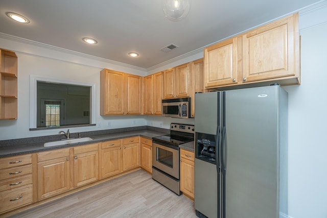 kitchen with dark countertops, appliances with stainless steel finishes, a sink, light wood finished floors, and visible vents