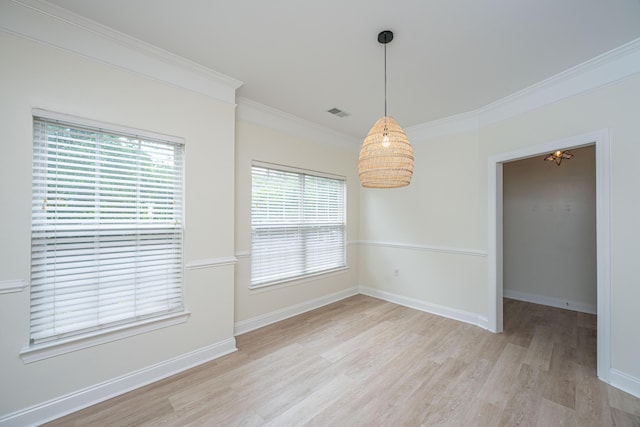 unfurnished dining area featuring crown molding, baseboards, visible vents, and light wood finished floors
