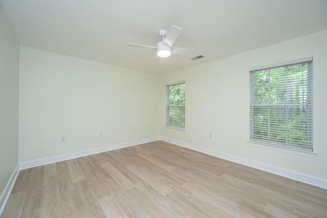 unfurnished room with a healthy amount of sunlight, baseboards, and light wood finished floors